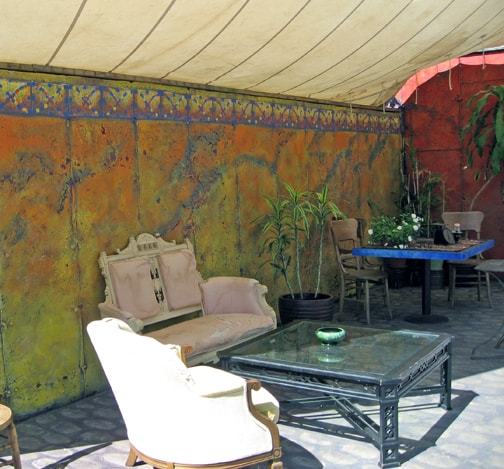 A poured concrete wall has become an exotic background for a place to have tea, or a conversation with friends.